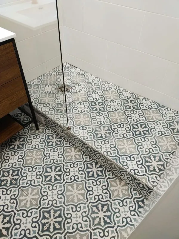 Douche avec sol en carreaux de ciment et paroi vitrée