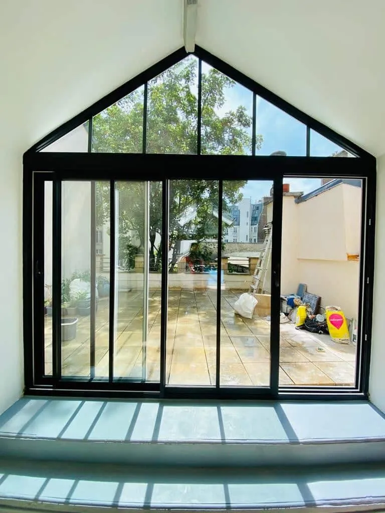 Extension vitrée à pignon avec baies coulissantes, réalisée par Rénove SAS à Paris 20e