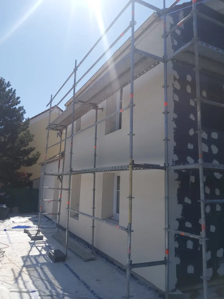 Chantier d’isolation thermique par l’extérieur : échafaudage et panneaux isolants en façade
