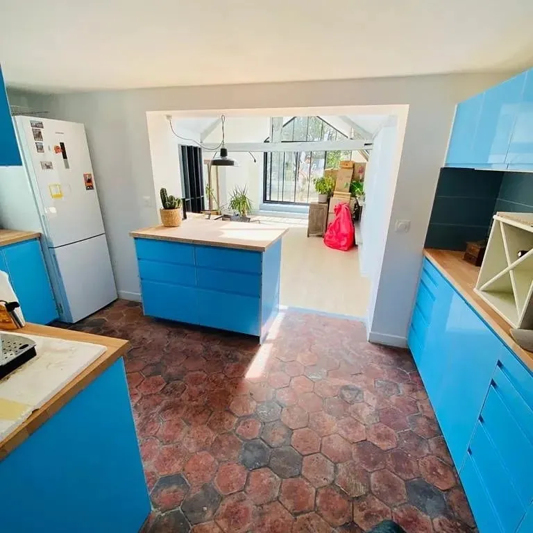 Cuisine bleue ouverte sur une extension vitrée, pavillon rénové à Paris 20e